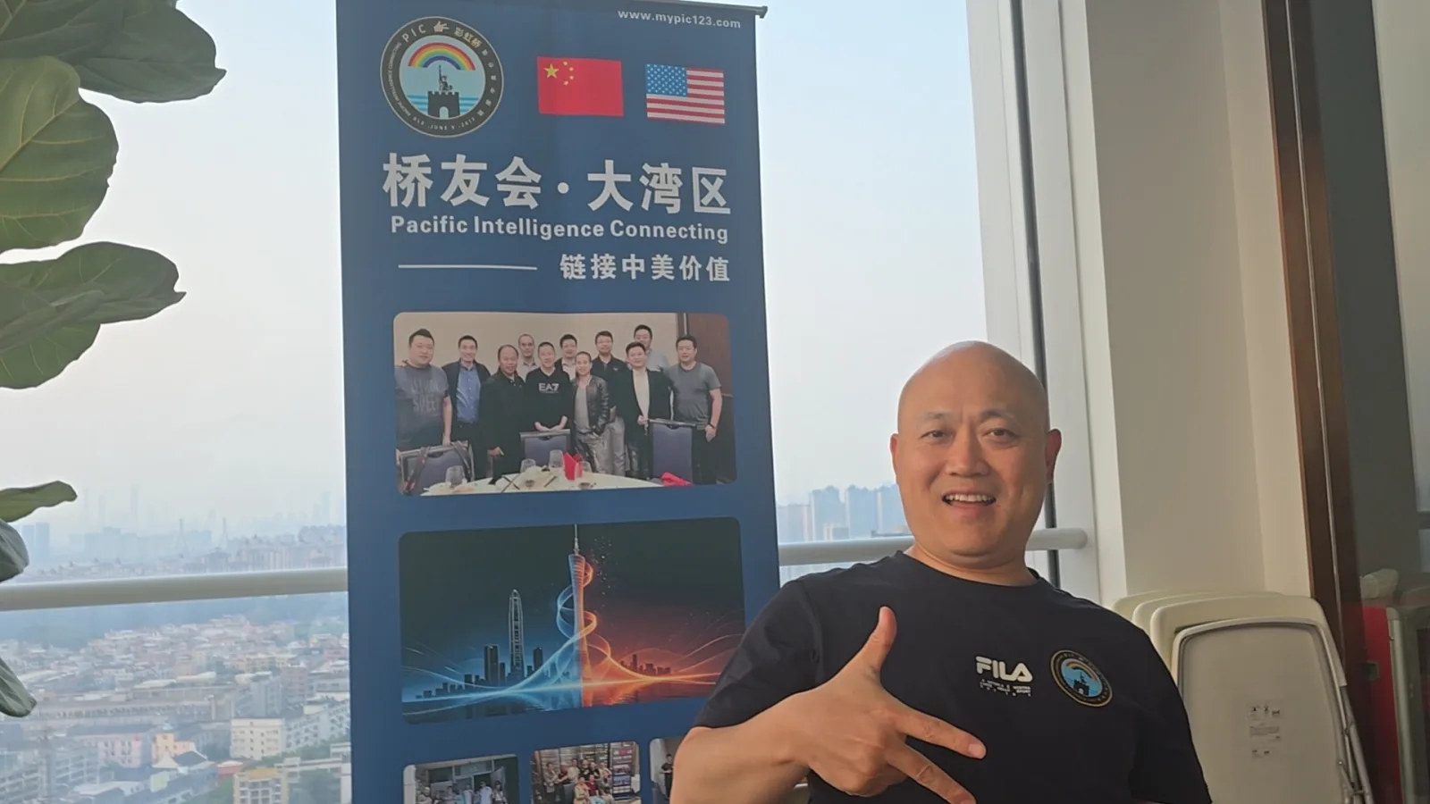 彩虹桥 9/5 广州番禺桥友会:一位桥友在落地窗前的易拉宝旁留影